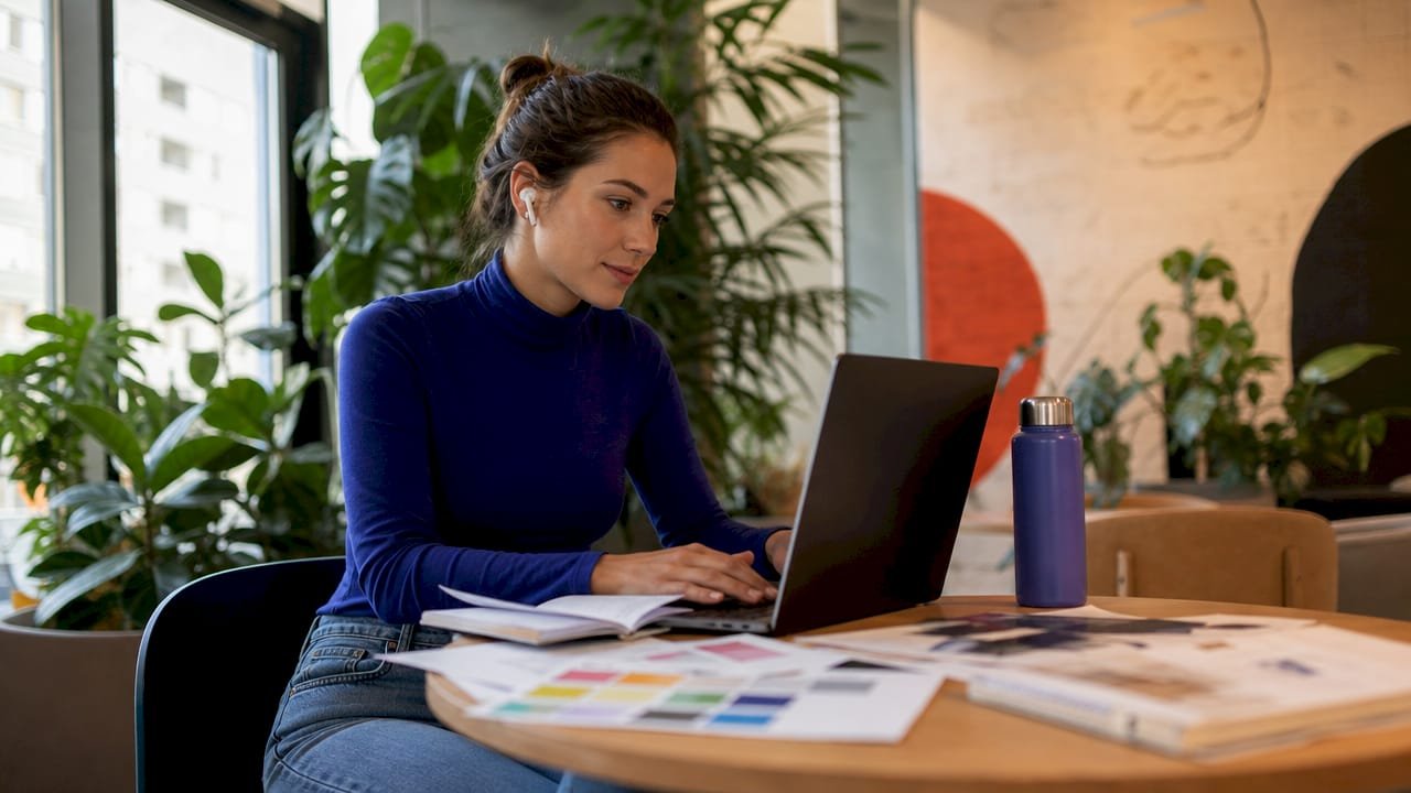 Marketing manager reviewing product sourcing on laptop