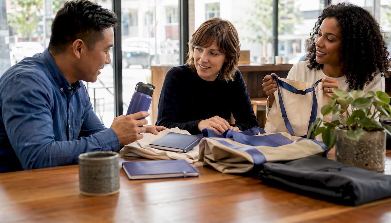 Team discussing launch swag items at office table