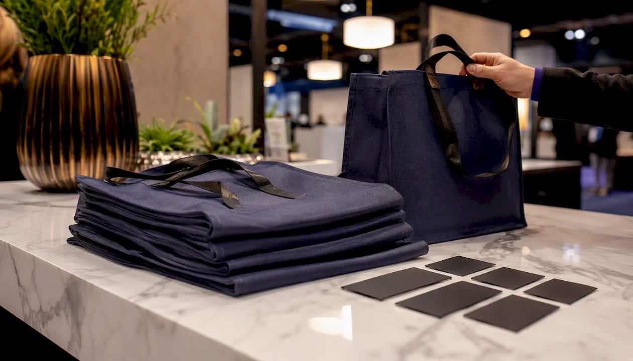 Stack of branded tote bags on trade show table