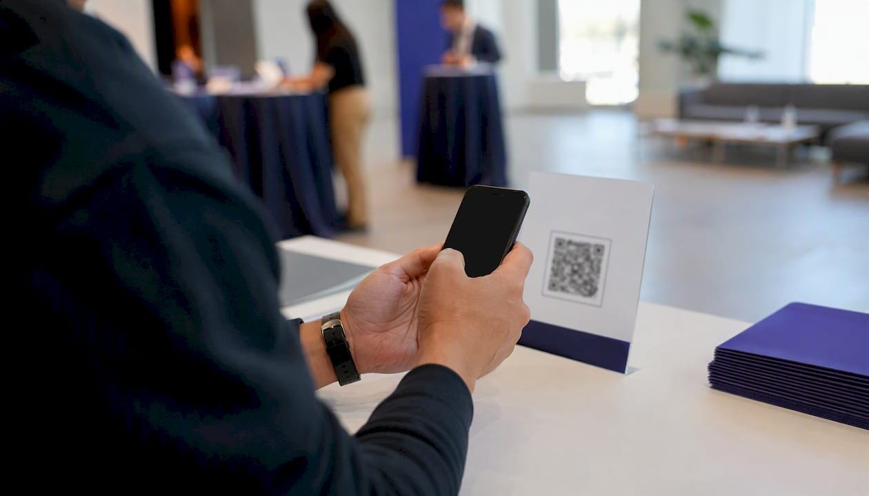 Hand scanning digital giveaway QR code at event booth