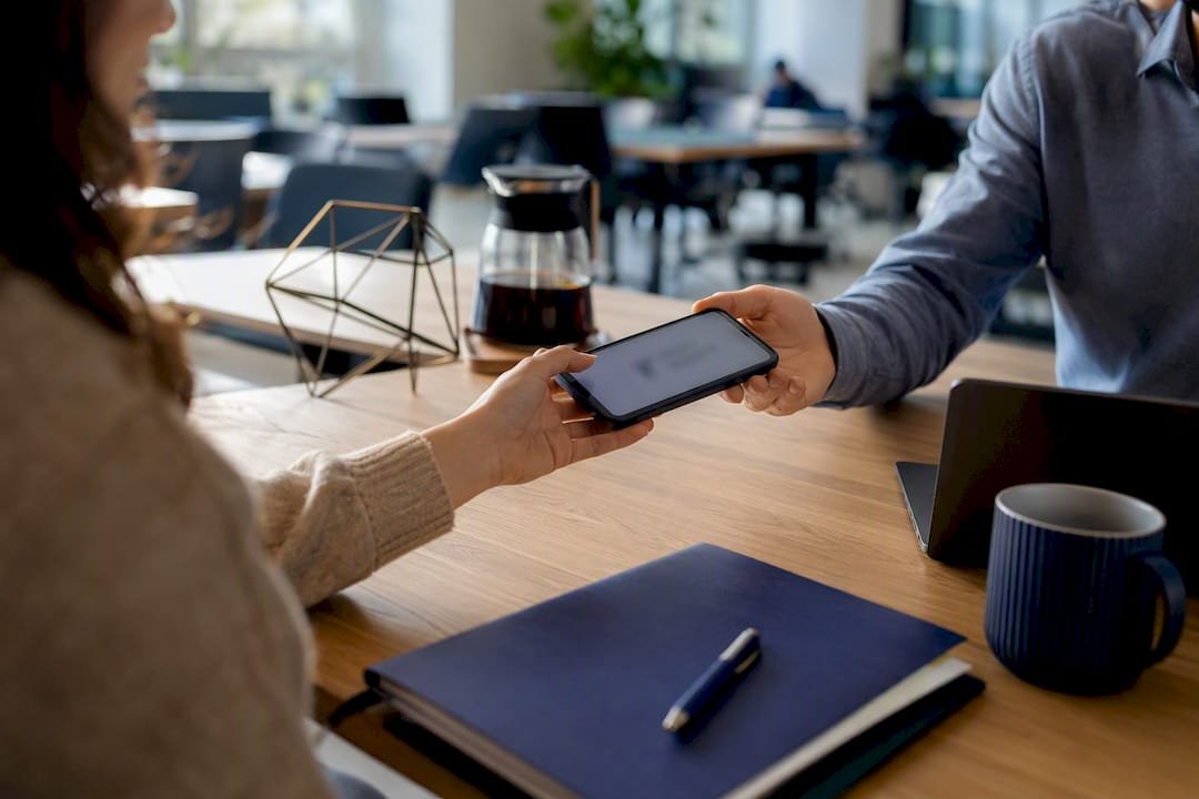 Hands holding smartphone with email signature update